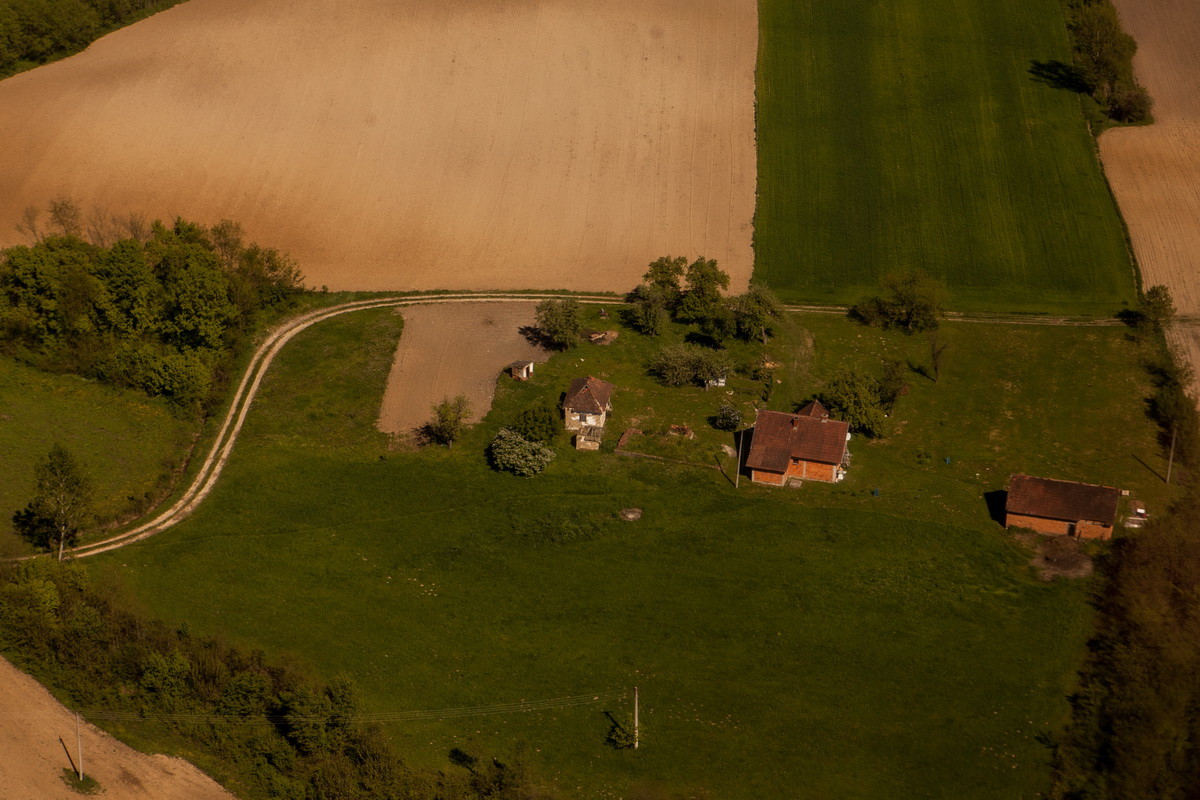 Pogled iz vazduha na seosko domaćinstvo i njive